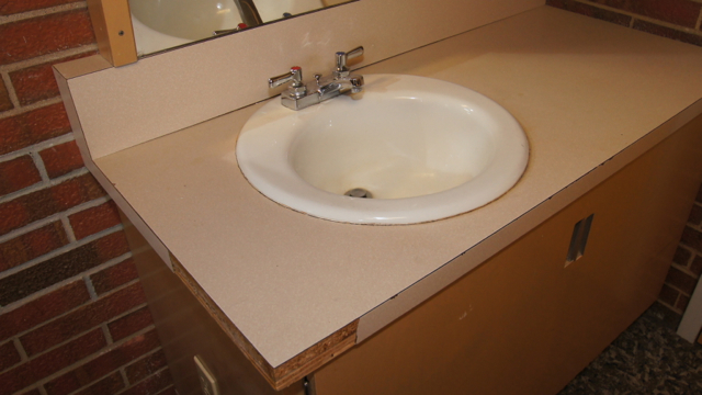 BEFORE: The vanities were dated and many had missing pieces of laminate.