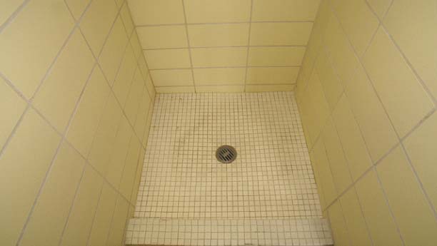 BEFORE: The 50-year old showers were worn, leaking and many had damaged tile.